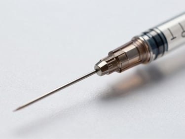 Macro close-up of sterile medical syringe needle bevel under clinical white laboratory light, shadowless, high-contrast engineering precision, surgical steel detail.