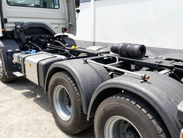 Close-up of a truck chassis being measured with precision tools in a clean Indonesian vehicle workshop, bright natural daylight, clean high-contrast industrial tones, sharp focus, 35mm lens