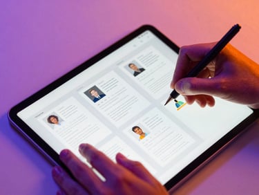 Overhead macro shot of a modern digital workspace, hands sketching newsletter layouts on a tablet, vibrant violet and orange gel highlights, sharp focus, 35mm