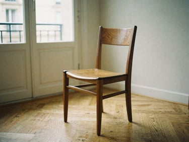 A beautiful mid-century wooden dining chair standing in a sunlit Parisian apartment, warm natural light, 35mm photography