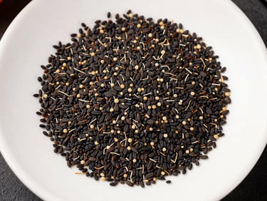 Overhead flat-lay of dried black seed (nigella sativa) pods and loose seeds scattered on a white ceramic tray under north-facing studio light, seed oil dropper bottle visible at the edge