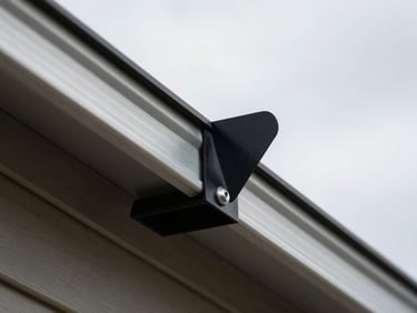 Extreme close-up of a solar panel mounting bracket bolted to a residential roof rail under flat overcast Canadian daylight, aluminium rail and black panel frame edge visible, no people, documentary framing
