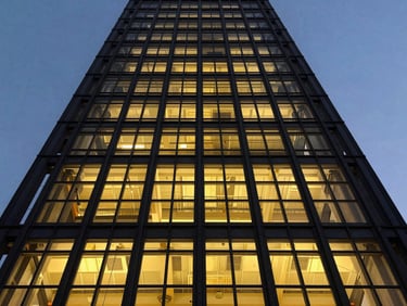 Low-angle architectural shot of a steel skyscraper facade in Bangalore, structural grid lines visible under dramatic twilight sky, sharp 35mm details