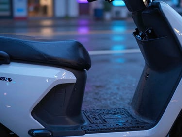 Extreme close-up of a premium leather seat and clean battery compartment of an electric scooter, subtle blue ambient lighting