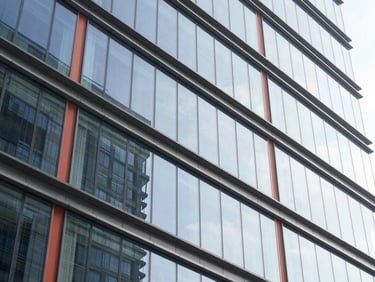 Abstract geometric glass and steel architectural lines reflecting bright morning light, representing growth and scale, 35mm