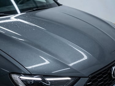 Water sheeting off a freshly cured ceramic coated car hood, sharp LED reflection lines, deep dark gray tones