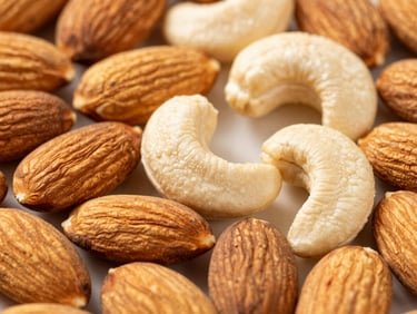 Bright macro shot of premium whole almonds and cashews, natural daylight, rich saturated earth tones