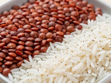 Clean daylight shot of polished red lentils and long-grain Basmati rice sorted on a grading tray