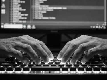 Close-up of hands resting on a mechanical keyboard, monitor glow illuminating fingertips, version control diff visible on screen in background, black and white, direct frontal framing, studio tungsten lighting