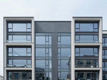 Straight-on symmetrical architectural elevation of a modern commercial facade with clean structural lines, overcast sky, sharp glass reflections