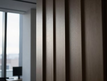 Architectural detail of a modern UK office interior, focusing on clean lines and natural light, with a subtle screen glow from a distant monitor, moody directional light, cool desaturated tones, sharp 35mm lens, high contrast, right third.