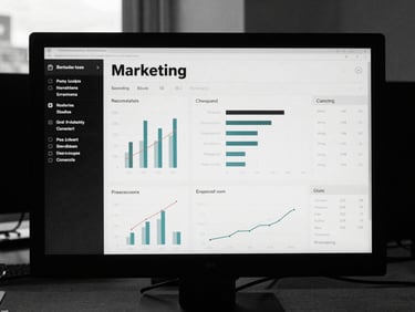 Clean digital dashboard showing real marketing metrics on a monitor, high contrast desaturated tones, low-key natural daylight, 35mm film.