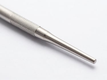 Macro shot of a serrated dental probe, stainless steel texture, bright clinical lighting, sterile white background.
