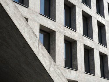 Modern minimalist concrete building facade in Munich, sharp geometric shadow lines, bright natural daylight, architectural photography, 35mm