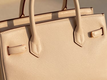 warm editorial fashion photography close-up of a luxury leather handbag and rose-gold jewelry details, warm sand tones, shallow depth of field, 35mm