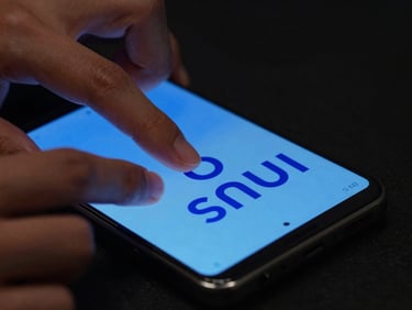 Extreme close-up of physical hands typing on a modern Android phone, displaying a minimalist writing interface with electric blue typography, moody low-key studio lighting