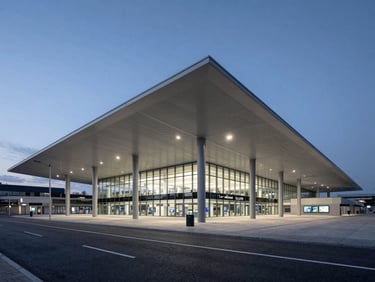 Crisp architectural photography of a modern European transit hub at blue hour, clean geometric lines, desaturated urban tones, wide-angle lens, sharp focus
