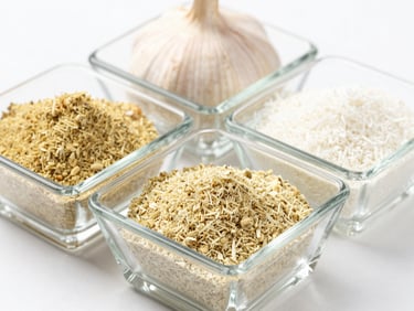 Macro studio shot of clean dehydrated garlic powder and white onion powder in geometric glass dishes, bright high-key lighting, sharp focus.