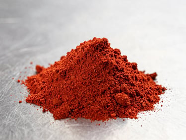 Macro shot of vibrant red tomato powder piled in a clean geometric cone on a sterile stainless steel surface, bright high-key studio lighting, sharp focus