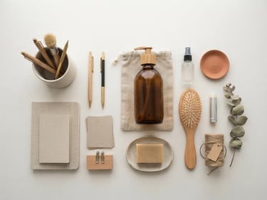 Overhead flat-lay of neatly organized stationery and natural household bottles on a clean white surface, bright diffused morning light, soft shadows, 50mm