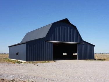 Low-angle shot of a completed engineered metal barn standing in a flat Texas pasture, wide gravel driveway, high contrast.