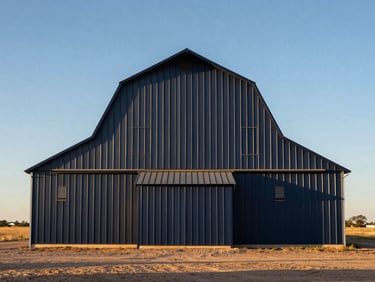 Straight-on architectural low-angle shot of a massive engineered metal barn standing in a dusty Texas pasture under a harsh golden hour sun, high contrast.