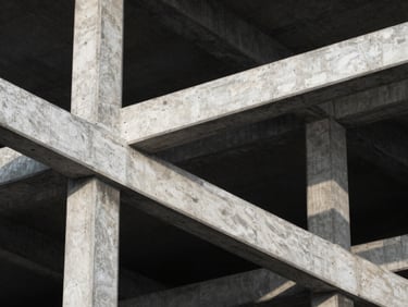 Architectural close-up of high-density concrete and steel structures, high-contrast side-lighting, cold tones.