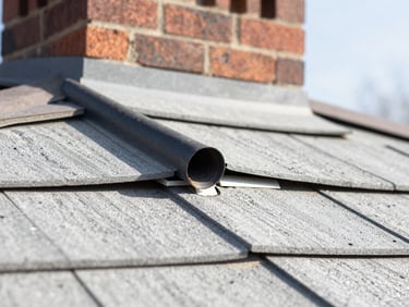 Macro detail shot of damaged roof flashing near a brick chimney, bright natural daylight, professional editorial photography