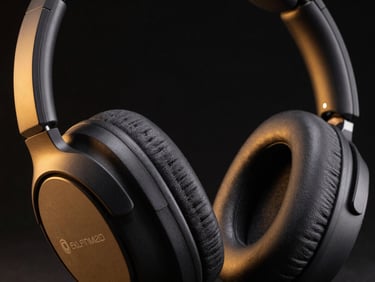 Close-up product thumbnail of wireless noise-cancelling headphones on near-black background, amber accent rim light on left edge