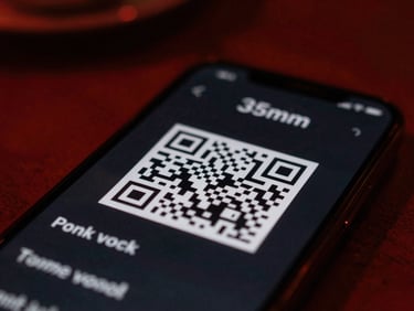 Macro shot of a smartphone displaying a dark-themed QR menu, with a blurred background of a dimly lit restaurant table, sharp crimson red highlights.