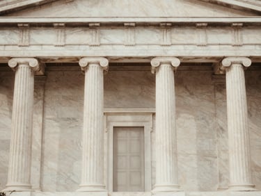 Muted tone photograph of a neoclassical building facade in Athens, marble textures, soft natural daylight.