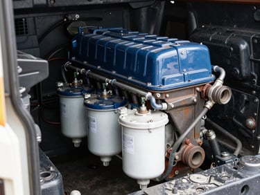 A clean heavy-duty truck diesel engine compartment showing fuel filters, bright workshop lighting, technical focus