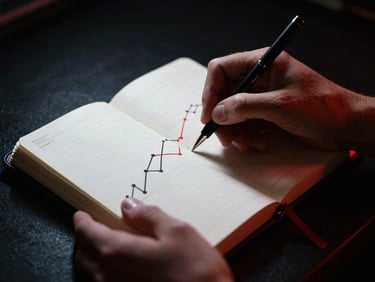 Dramatic close-up of hands drawing strategic growth charts in a premium black leather notebook, high-contrast rim light