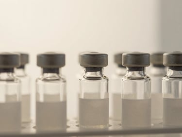 Macro shot of high-end diagnostic laboratory glass vials, soft natural light, warm alabaster background, clean minimalist composition, 35mm