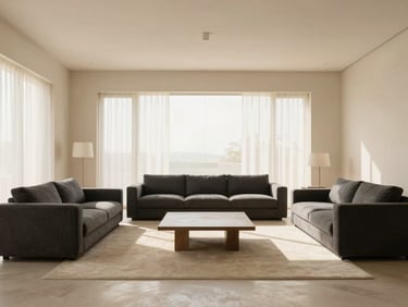 Wide-angle architectural shot of a minimalist Indian living room, soft morning light, cream and charcoal tones, architectural lens, 35mm