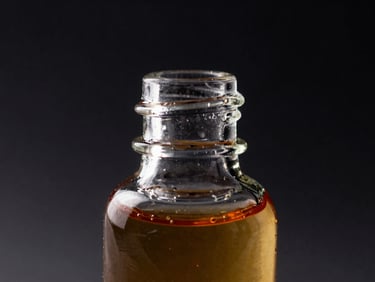 Macro studio shot of clean e-liquid bottle showing thick amber liquid viscosity, sharp rim light on glass dropper, dark background, 16:9 landscape aspect