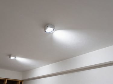 Perfectly smooth unpainted drywall seams under raking work lights, crisp jobsite photography