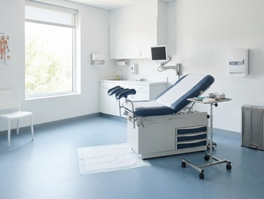 Bright high-key commercial photography of a pristine, empty medical exam room, crisp clean daylight, clinical blue and white tones, sharp focus, 35mm