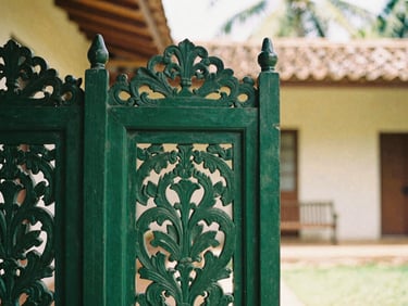 Close-up of a hand-carved wooden screen in a restored colonial villa, soft tropical daylight, 35mm look.