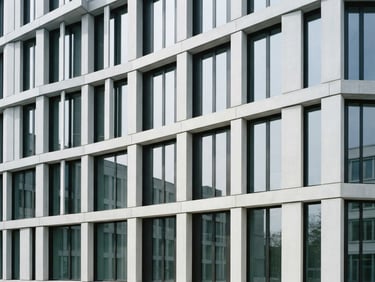 Minimalist architectural photography of a modern concrete office facade, bright neutral daylight, cool corporate tones, sharp focus, clean lines, 35mm lens.