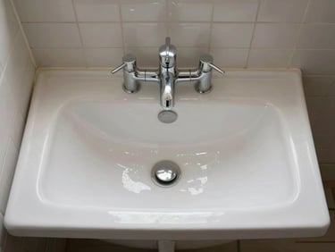 Overhead flat-lay photograph of a freshly cleaned bathroom with scrubbed tiles, polished taps, and an empty bath, bright even studio lighting, no people present
