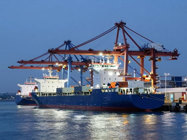 A modern deep-water port at twilight with clean architectural lighting, cargo vessels docked, cool blue and white glows.