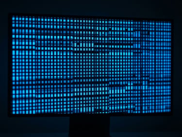 Extreme close-up of a high-contrast digital interface on a sleek monitor, sharp macro focus on glowing electric blue pixels and fine grid lines, dark minimalist workspace, crisp studio lighting, 16:9 aspect.