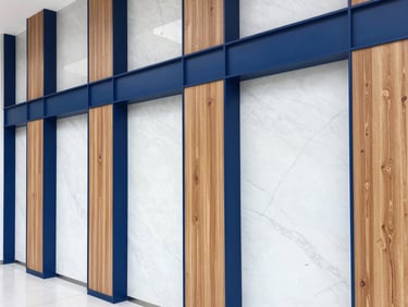 Modern commercial office wall featuring sleek wood slat panels and seamless marble alternatives, bright lighting.
