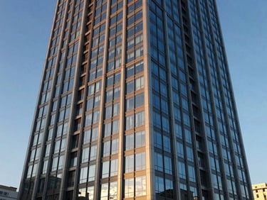 Finished high-rise facade with modern glass panels reflecting the blue sky, crisp architectural photography, 35mm