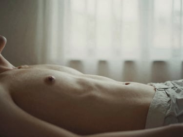 A person resting in soft, diffused natural window light, muted earthy tones, shallow depth of field, 35mm film style.
