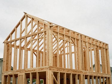 Exposed timber framing of a new residential home under natural overcast daylight, warm earthy tones, sharp architectural detail.