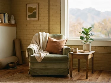 Quiet, sunlit corner of a somatic therapy studio in Salt Lake City, soft diffused afternoon sunlight, earthy green and muted gold tones, shallow depth of field, 35mm film texture.