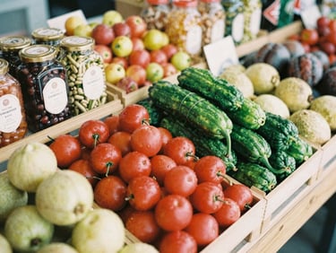 Overhead shot of a vibrant modern food market stall, displaying colorful produce and artisanal goods, soft natural light, focus on texture, warm editorial photography.