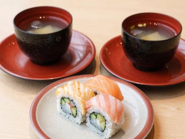 Two plates of assorted sushi rolls paired with cold ocha, minimalist Japanese table setting